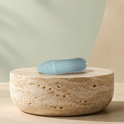 Doigtier brosse à dents en silicone posé sur un socle en travertin